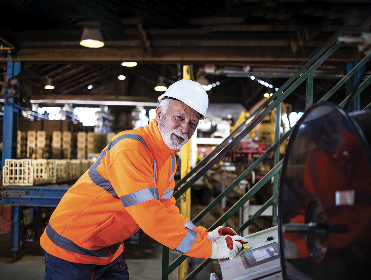 factory worker operating industrial machine in production hall.
